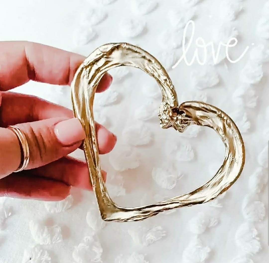 Handcrafted Heart Umbilical Cord Keepsake – Heritage of Care artisan-made golden heart-shaped umbilical cord keepsake held against marble background