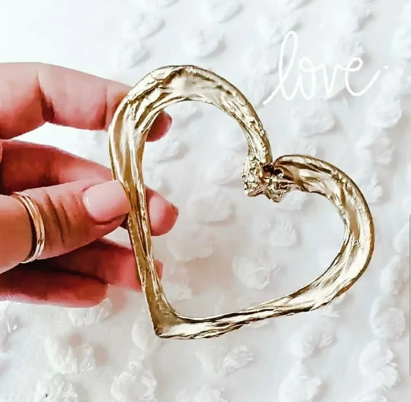 Handcrafted Heart Umbilical Cord Keepsake – Heritage of Care artisan-made golden heart-shaped umbilical cord keepsake held against marble background